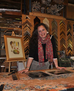 Gallery owner Rebecca Fay poses at the framing counter in the gallery.